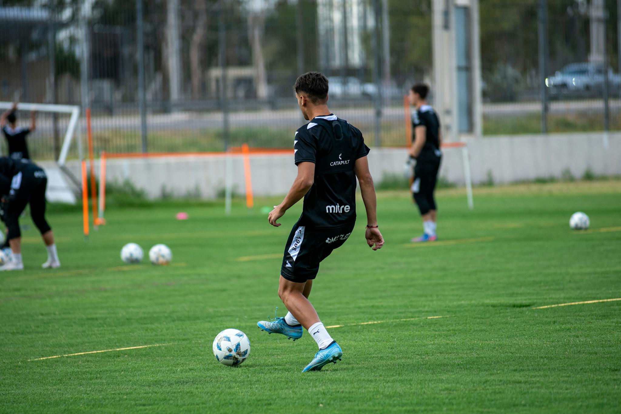 Soccer players in a training session on an outdoor field, showcasing teamwork and skills.